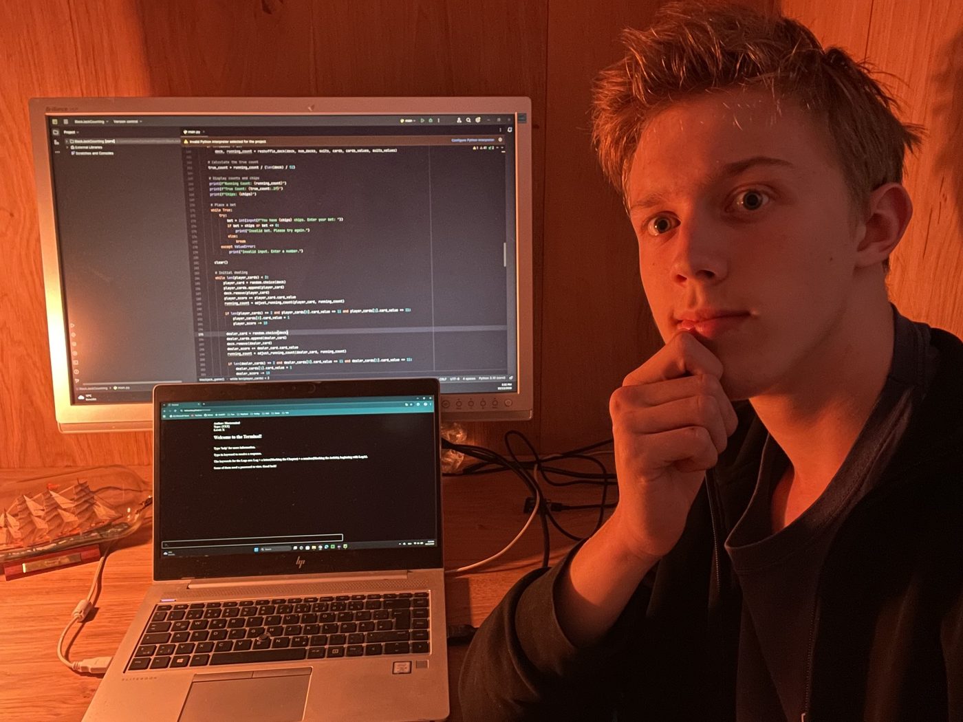 Luis vor Code auf zwei Bildschirmen